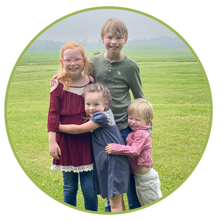 The four Templin children hugging together in a green field